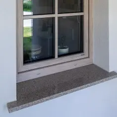 Kamienny parapet pod oknem, gotowy do montażu. Praktyczny poradnik, jak osadzić parapet, pomoże Ci wykonać tę pracę.