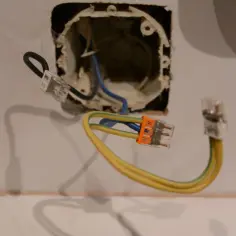 Instalacja elektryczna: jak podłączyć wtyczkę bez uziemienia. Widoczne przewody połączone złączkami.