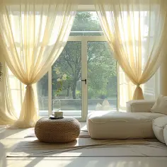 Jasne, zwiewne firanki w salonie upięte w elegancki sposób, tworzą przytulną atmosferę.
