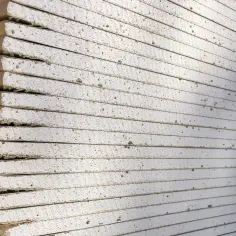 Stos płyt gipsowo-kartonowych, widoczna ich grubość i porowata struktura.