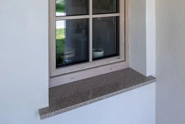 Kamienny parapet pod oknem, gotowy do montażu. Praktyczny poradnik, jak osadzić parapet, pomoże Ci wykonać tę pracę.